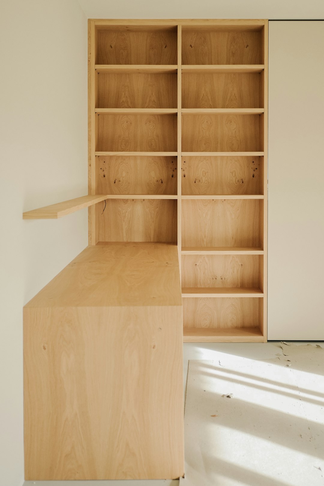 light-wood-desk-and-bookshelf-against-a-wall-s-wcaesejbu